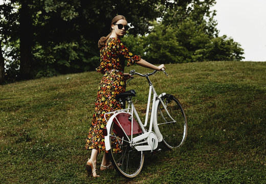 Vintage model in the park with bicycle