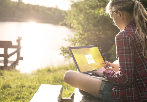 User with Laptop in the Outdoors Mockup 1