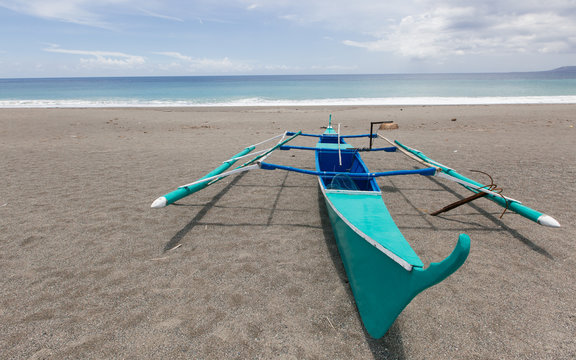 A fishing boat with outrigger on the shore