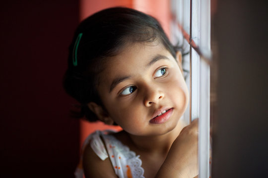 Close up portrait of cute little girl looking away