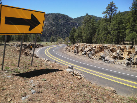 Road sign arrow points to the curve