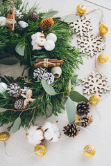 Homemade Christmas wreath on white wooden table