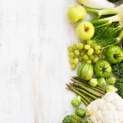 Above view, table top green vegetables and fruits on the white wooden table, copy space for text on the left, square, top view, selective focus