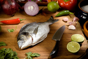 whole sea bream with raw ingredients