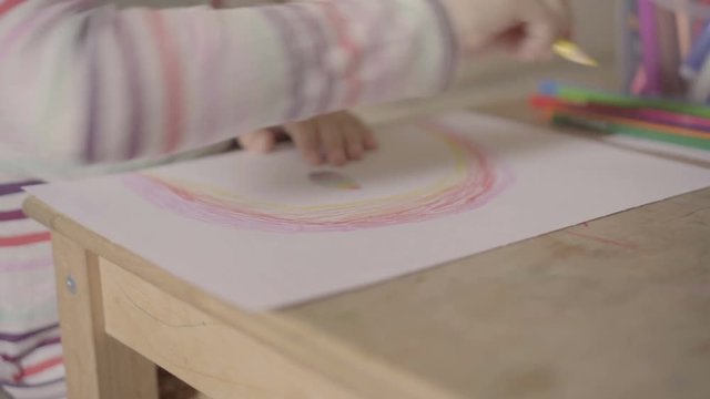 preschool girl drawing a picture with pencils close-up