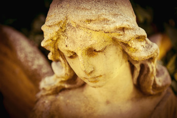 Antique statue of gold angel in the sunlight. (religion, faith, death, resurrection, eternity concept)