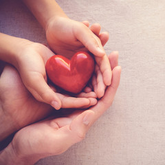 adult and child hands holiding red heart, health care love and family concept, foster home care, happy volunteer donation charity, world health day, world heart day