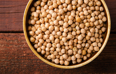 Chick-pea in bowl on wooden background. Horizontal