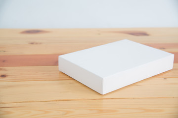 Empty white gift on wooden table with copy space.