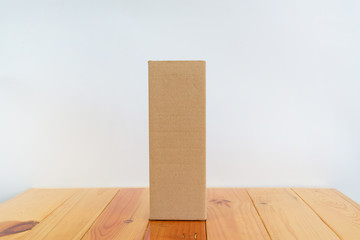 Empty Package brown cardboard box for long items on wooden table with copy space.