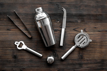 Instruments bartender. Shaker, strainer on wooden background top view