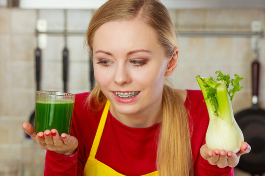 Woman in kitchen holding vegetable fennel smoothie juice