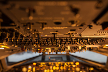A lot of switches in aircraft cockpit with selective focus.