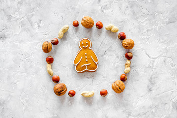Healthy food for sportsman. Cookies in shape of yoga asanas near nuts on stone background top view...