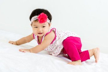 Portrait of adorable baby sliding on a sloped floor  with head band