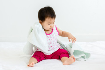 Fototapeta premium Portrait of adorable baby sitting with towel, indoors