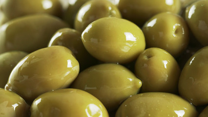Large shiny green olives macro background