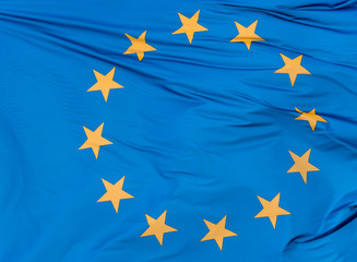 European Union flag on blue sky background, close up.