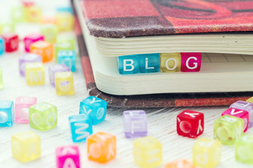 Word blog written on a colored block in a book on table.