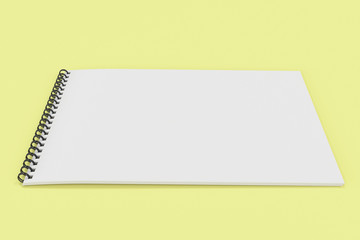 Blank white notebook with black spiral bound on yellow background