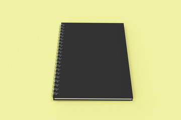 Closed notebook spiral bound on yellow background