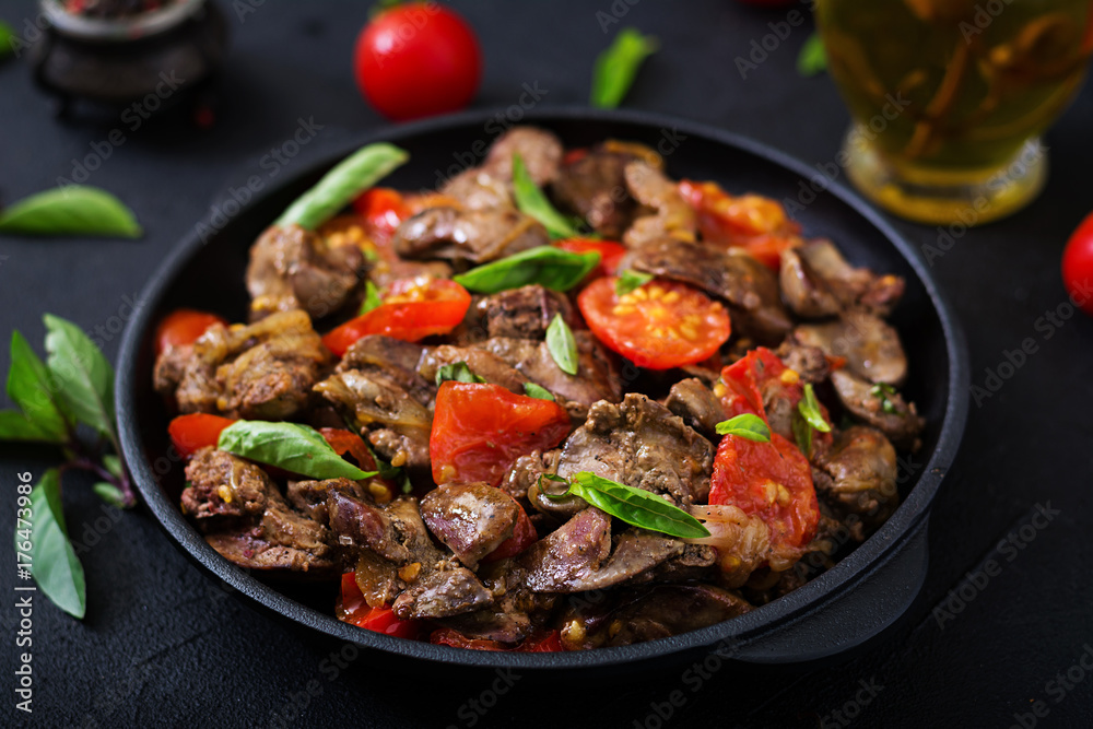 Wall mural chicken liver (offal) with onions and tomatoes in a frying pan in armenian