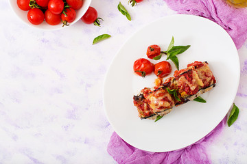 Eggplant (aubergine) rolls with meat in tomato sauce. Flat lay. Top view