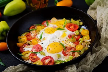 Fried eggs with vegetables - shakshuka in a frying pan on a black background © timolina