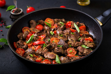 Chicken liver (offal) with onions and tomatoes in a frying pan in Armenian