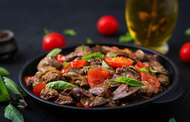 Chicken liver (offal) with onions and tomatoes in a frying pan in Armenian