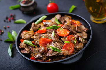 Chicken liver (offal) with onions and tomatoes in a frying pan in Armenian