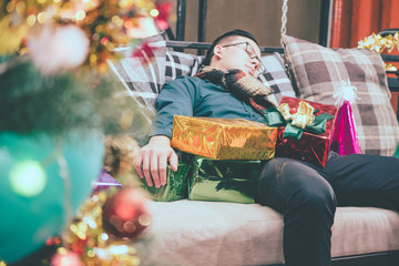 Sleeping man on a sofa after Christmas party.