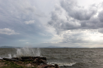 Water splashing on rocks and stones, beneath a moody sky