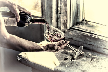 toned. Pouring wine on a old background