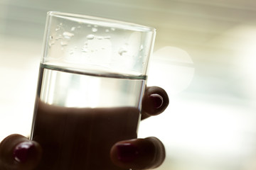 Woman holding a glass of water, close-up
