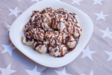 Christmas, new year cake from profiteroles with chocolate on fabric with stars.