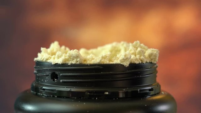 Macro close up of woman scooping pure nutritional supplement whey protein powder from container.
