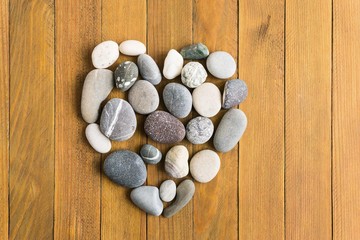 Fototapeta na wymiar stone heart on a wooden board background
