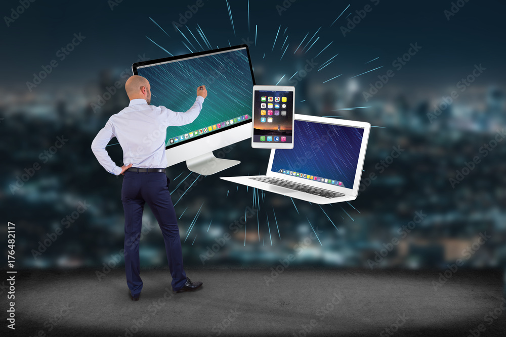 Poster businessman in front of a wall with computer and devices displayed on a futuristic interface - multi