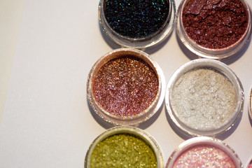 Cosmetics. Pigments for make-up, eyes, lips, face and body. Brilliant radiant, scattered multicolored powders.