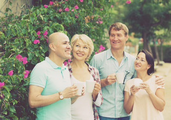 males and females drinking coffee outdoors