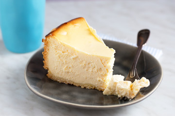 Homemade german cheesecake on beautiful plate on white table. Natural light, selective focus.