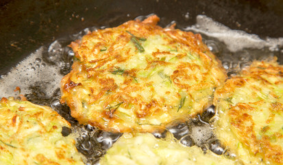 Fritters are fried in oil in a frying pan