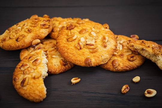 Cookies with peanuts on dark wooden background