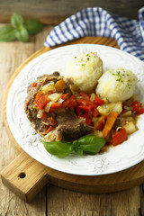 Meat served with vegetable stew and potato dumplings