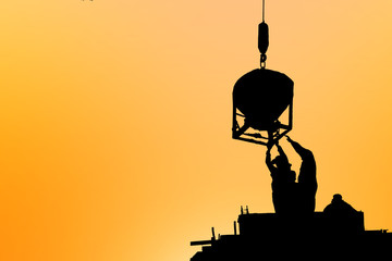 silhouette construction team working on high ground over blurred background sunset sky.