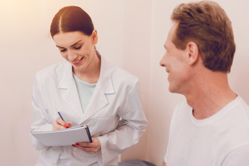 Fototapeta premium Attentive young doctor making notes