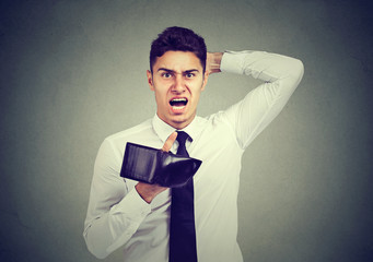 Shocked, frustrated angry man, holding an empty wallet