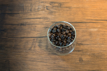 Coffee bean in the glass on wooden table