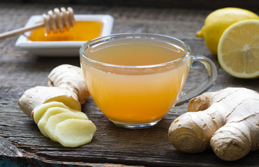 Ginger homemade tea infusion on wooden board with lemon

